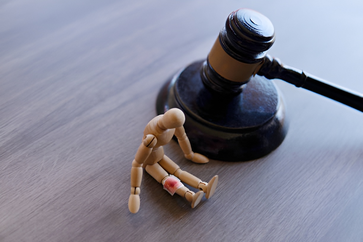 wooden doll with blood-stained bandage, next to a gavel